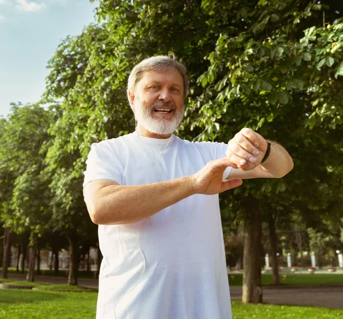Older man checking his watch during a walk in the park